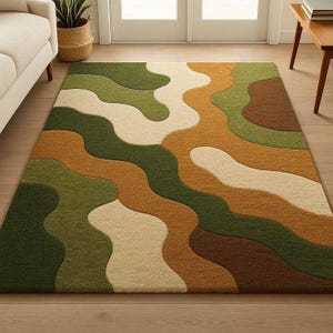 Könnte beinhalten: Ein rechteckiger Teppich mit einem wellenförmigen, geschichteten Design in Grün-, Braun- und Beigetönen. Das Muster des Teppichs erzeugt einen fließenden, organischen Look, der für ein Wohn- oder Schlafzimmer geeignet ist. Der Teppich besteht aus einem weichen, plüschigen Material.