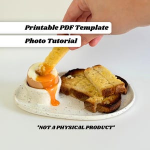 Può includere: Un uovo alla coque con tuorlo liquido in un portauovo di ceramica macchiata, servito con pane tostato. L'immagine include il testo "Printable PDF Template Photo Tutorial" e "*NOT A PHYSICAL PRODUCT*".