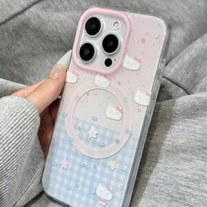 May include: A clear phone case with a pink and blue design. The case features a pink border, a Hello Kitty pattern, and a blue and white checkered pattern. The text "Y2kXCases" is at the top.