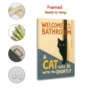 May include: Framed canvas art with the text "WELCOME TO THE BATHROOM" and "A CAT WILL BE WITH YOU SHORTLY". The artwork features a black cat peeking from behind a door. The background is a light beige with a blue floor.