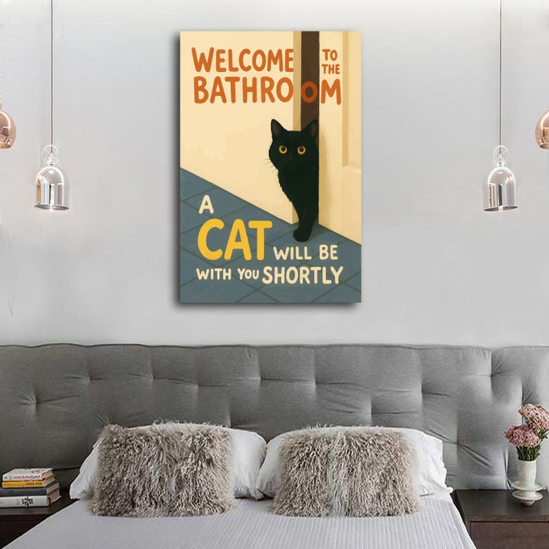 May include: A rectangular canvas print with the text "WELCOME TO THE BATHROOM" and "A CAT WILL BE WITH YOU SHORTLY." A black cat with yellow eyes peeks out from behind a door. The background is a light beige with a blue and gray floor.