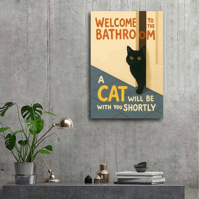 May include: A rectangular wall art print with the text "WELCOME TO THE BATHROOM" and "A CAT WILL BE WITH YOU SHORTLY". The artwork features a black cat peeking out from behind a door.