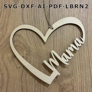 Könnte beinhalten: Ein herzförmiger Holzschmuck mit dem Wort "Mama" in Schreibschrift. Der Anhänger ist aus hellem Holz gefertigt und hat eine natürliche Oberfläche. Er hängt an einer Schnur. Der Text "SVG.DXF.AI.PDF.LBRN2" ist oben zu sehen.