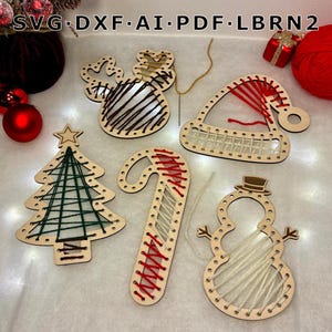 Può includere: Cinque decorazioni natalizie in legno con fori pretagliati per l'intreccio, tra cui una renna, un cappello da Babbo Natale, un albero, un bastoncino di zucchero e un pupazzo di neve. Filo rosso, verde e bianco. Testo: SVG DXF AI PDF LBRN2.