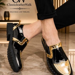 Op de afbeelding: Een paar zwarte lakleren instapschoenen met metallic gouden brogue-stijl accenten op de neus en zijpanelen. De schoenen hebben een dikke zwarte profielzool en een glanzende afwerking. Het logo CW ClassicleatherWalk is duidelijk zichtbaar.