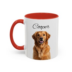 May include: A white ceramic mug with a bright red handle and interior rim. The front of the mug features a realistic color photograph of a golden retriever dog with its mouth slightly open. Above the dog, the name Cooper is printed in black.