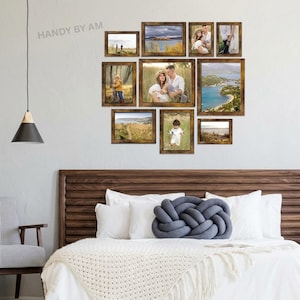 May include: A collection of ten framed photographs with rustic brown wooden frames, arranged on a white wall. The photos depict various scenes, including landscapes and portraits. The arrangement is above a bed with white bedding and a decorative knot pillow.