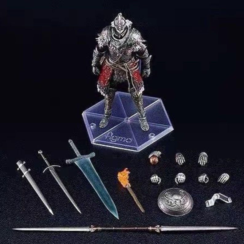 May include: A detailed action figure of a knight in silver armor with red accents, standing on a clear hexagonal base. Includes various accessories: swords, a torch, a shield, and interchangeable hands. The figure is highly detailed and appears to be from a fantasy genre.
