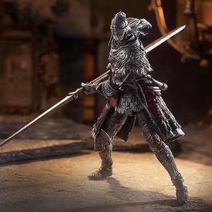 May include: A detailed figurine of a warrior in ornate armor, holding two large swords. The figure is predominantly silver and red, with intricate detailing on the helmet, chest, and legs. The warrior is posed in a dynamic stance, suggesting action.