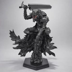May include: A detailed black statue of a warrior in armor, holding a large sword overhead. The figure has a helmet with horns and glowing red eyes. The statue is mounted on a black hexagonal base, showcasing a fantasy theme.