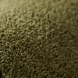 May include: A close-up view of a textured olive green fabric with a dense, looped pile surface. The material features a consistent, soft, and fuzzy appearance with small, uniform loops creating a tactile, uneven surface across the entire frame.