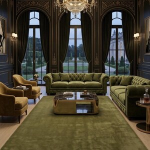 May include: A living room set featuring two olive green tufted velvet sofas, two mustard yellow armchairs, and a square coffee table with a black marble top and gold base. A large olive green area rug covers the light wood floor beneath.