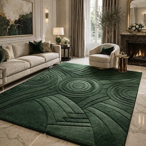 Peut inclure: Un tapis vert foncé avec un motif géométrique dans un salon. Le tapis présente des cercles concentriques et des lignes courbes, créant un effet texturé. La pièce comprend un canapé beige, un fauteuil et une cheminée.