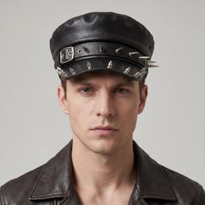 Puede incluir: Gorra de cuero negra con p&uacute;as plateadas y cierre de hebilla. La gorra tiene una copa redondeada y una visera corta y r&iacute;gida. Las p&uacute;as est&aacute;n espaciadas uniformemente a lo largo del borde y la parte superior, dando un aspecto audaz.