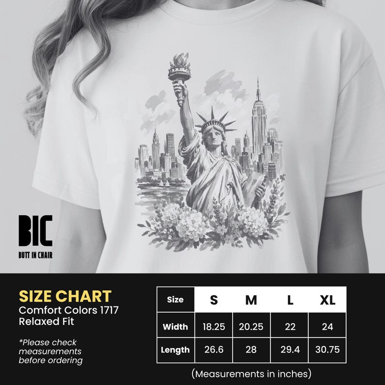 Puede incluir: Camiseta blanca con una ilustraci&oacute;n en blanco y negro de la Estatua de la Libertad y el horizonte de Nueva York. La camiseta tiene un corte relajado. La anchura es de 56 cm para la talla XL.
