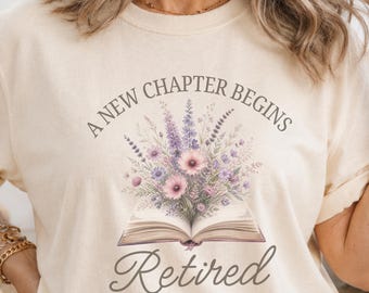 Camiseta de aposentadoria feminina, "Um novo capítulo começa: Aposentadoria em 2026", estampa floral, presente para mulheres que amam livros e desejam se aposentar.