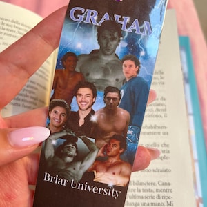Op de afbeelding: Een rechthoekige boekenlegger met een paars lint. De boekenlegger heeft een collage van afbeeldingen van mannen, met het woord "GRAHAM" bovenaan en "Briar University" onderaan. De achtergrond heeft een blauw bliksemontwerp.