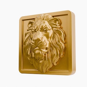 May include: A golden lion head sculpture in a square frame. The lion's mane and facial features are intricately detailed. The sculpture is a solid gold color and has a three-dimensional appearance.