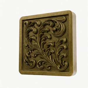 May include: A square, antique gold-coloured wall plaque featuring a raised, three-dimensional relief of intricate, swirling acanthus leaf scrollwork. The design is centred within a smooth, raised border, showcasing a metallic finish with subtle shading.