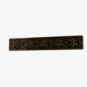 May include: A rectangular bronze-toned metal drawer pull featuring a repeating embossed floral pattern with five distinct flower motifs separated by scrolling vine details, finished with a dark patina and a smooth, flat border frame.