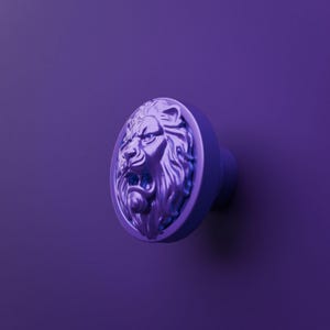 Könnte beinhalten: Ein runder violetter Möbelknopf mit einem dreidimensionalen Relief eines Löwenkopfes. Der Löwe ist mit einer detaillierten Mähne und offenem Maul dargestellt und in einem einfarbigen Violett gehalten, das dem Hintergrund entspricht.