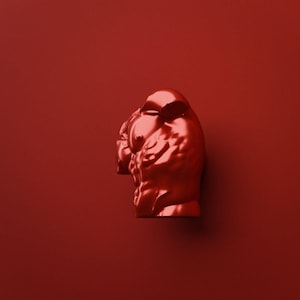 May include: A monochromatic red sculpture depicting the upper torso of a muscular figure. The object features a smooth, reflective surface with defined anatomical contours, including chest and shoulder muscles, presented in a solid red color.