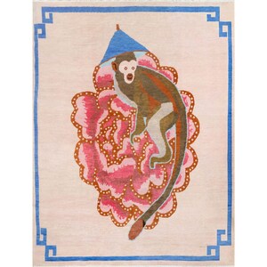 Può includere: Un tappeto rettangolare dal design stravagante. Il tappeto presenta una scimmia con un cappello blu, su uno sfondo floreale rosa. Un bordo blu incornicia il tappeto, aggiungendo un tocco decorativo. La tavolozza dei colori del tappeto comprende sfumature di rosa, marrone e blu.