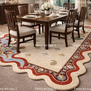 May include: A dining room scene featuring a large, ornate area rug with a cream-colored background and a decorative border in red, blue, and gold. The rug is under a wooden dining table and chairs.