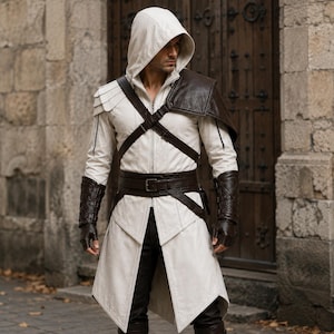May include: A white hooded jacket featuring a structured collar, a front zipper, and layered shoulder detailing. It is accented with dark brown leather-like straps, a wide buckled belt, and matching fingerless gauntlets over dark trousers.