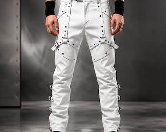 May include: White trousers featuring an integrated harness system with silver-toned metal studs, buckles, and straps. The pants include additional buckle details along the outer seams of each leg, a standard waistband with belt loops, and a front button closure.