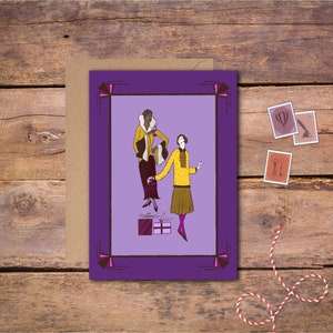 May include: A purple card with a decorative border features two women in vintage clothing holding glasses. The women are standing in front of a purple background with two wrapped gifts. The card has the text "Happy Holidays" printed on it.
