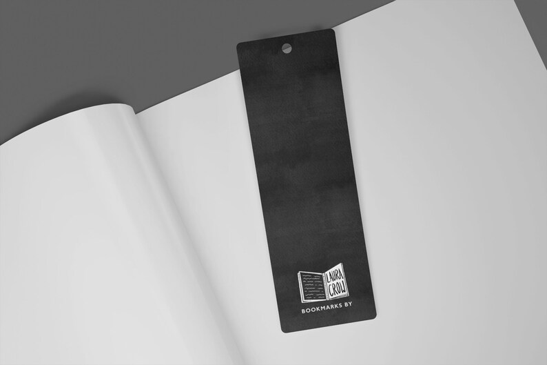 May include: A black bookmark with a white logo of an open book with the text "Laura Crow" and the words "Bookmarks By" below the logo.