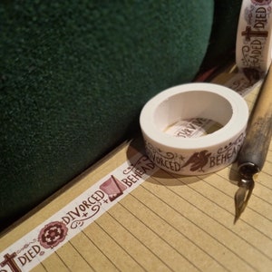 May include: Two rolls of washi tape with a white background and brown text. The text on one roll says "Survive, Divorced, Beheaded, Died". The text on the other roll says "Beheaded, Died".