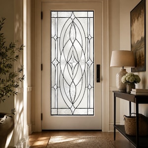 May include: A white entry door featuring a tall, rectangular glass insert with a decorative leaded pattern. The glass design consists of intersecting curved lines and diamond shapes, creating a symmetrical, geometric motif within the frame.