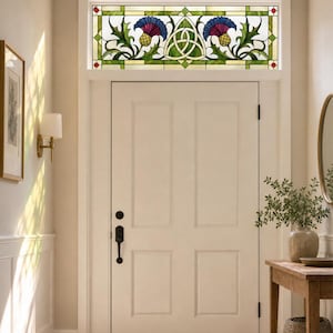 May include: A rectangular stained glass transom window featuring a central white triquetra knot design flanked by two stylized purple and blue thistle flowers with green leaves, set within a geometric frame with small red accents at the corners.