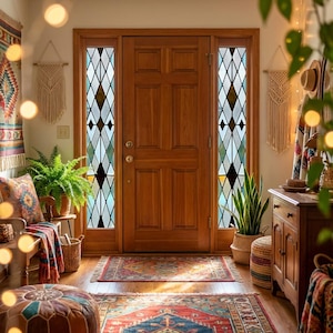 Puede incluir: Un recibidor cálido con una puerta de madera y vidrieras laterales. El espacio está decorado con una alfombra estampada, un banco con cojines y una manta, y tapices de macramé. Las plantas y un mueble de madera contribuyen a la estética bohemia.