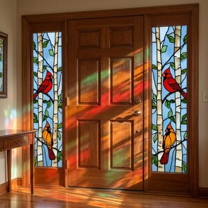 Può includere: Porta d'ingresso in legno con vetrate raffiguranti cardinali rossi e arancioni appollaiati su rami di betulle su sfondo di cielo blu. La porta in legno ha un aspetto caldo e invitante.