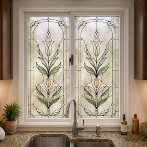 May include: A double-pane window featuring a decorative stained glass design with a symmetrical floral motif. The pattern displays cream-coloured tulip-like blossoms and sage green leaves encased in thin black lead lines against a textured glass.