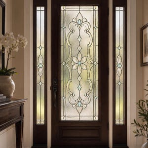 Könnte beinhalten: Eine dunkelbraune Holzeingangstür mit einem großen zentralen Glaseinsatz, der ein komplexes Bleiglasdesign aufweist. Das Muster umfasst ein zentrales Blumenmotiv, geschwungene Linien und kleine blaue Akzente, flankiert von zwei passenden Seitenteilen.