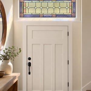 Peut inclure: Une imposte rectangulaire dotée d'un vitrail composé d'une rangée centrale de carreaux de verre transparents en forme de losange, entourée de bordures en verre texturé violet, bleu et ambre, le tout encadré au-dessus d'une porte blanche.