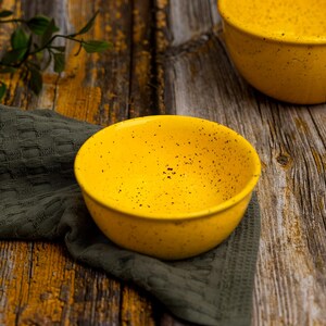Può includere: Una tazza di ceramica bianca con manico nero e la scritta "But First, Coffee" in nero, con un carattere a mano. La tazza è su una superficie bianca.