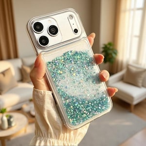 Op de afbeelding: Een doorzichtig smartphonehoesje met een met vloeistof gevuld achterpaneel dat een mix van blauwgroene, blauwe en zilveren stervormige glitters bevat. Het hoesje heeft een rechthoekige uitsparing voor de camera met drie ronde lensopeningen.