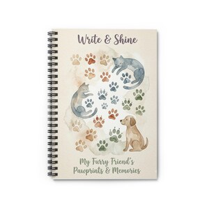 May include: Spiral-bound notebook with the text "Write & Shine" and "My Furry Friend's Pawprints & Memories." The cover features watercolor illustrations of cats, a dog, and paw prints in various colors. The notebook is designed for pet owners.
