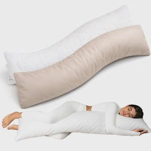 May include: Two long body pillows, one beige and one white, are shown. The beige pillow has a smooth surface, while the white pillow has a quilted pattern. A person is lying on a white body pillow, wearing white clothing.
