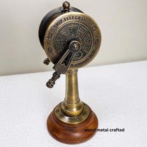 May include: A vintage brass ship telegraph with a wooden base. The dial reads "Ship Telegraph" and includes speed instructions like "Full" and "Slow." The base is wood metal crafted.