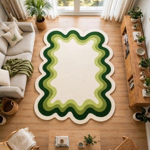 May include: A rectangular area rug with a wavy, scalloped edge featuring concentric layers of green and cream colors. The design consists of a large cream-colored center surrounded by multiple undulating bands of light, medium, and dark green.