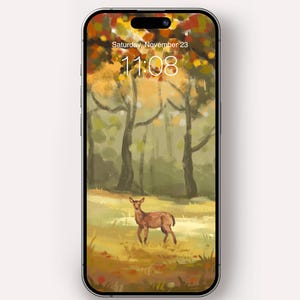 May include: A smartphone screen shows a digital wallpaper titled 'Through Amber Woods'. The image depicts a deer in a forest with autumnal hues. The time displayed is 11:08 on Saturday, November 23. The Silent Meadow Studio logo is at the bottom.