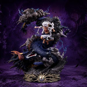 Peut inclure: Une figurine de style anime dynamique représentant un personnage aux cheveux blancs et aux vêtements blancs sautant au-dessus d'un grand dragon bleu foncé enroulé. La scène inclut des effets de fumée grise, des éclairs bleus et une base circulaire.