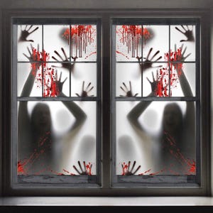 May include: A window decal set featuring red blood splatters and black handprints on a translucent background. The design includes silhouettes of two figures with raised arms, creating a layered effect across the glass panes of the window.