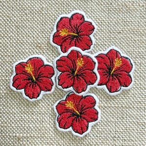 May include: Five embroidered hibiscus flower patches featuring vibrant red petals with detailed black stitching and a prominent yellow stamen in the centre. Each flower is outlined with a white border, creating a distinct shape for each individual patch.